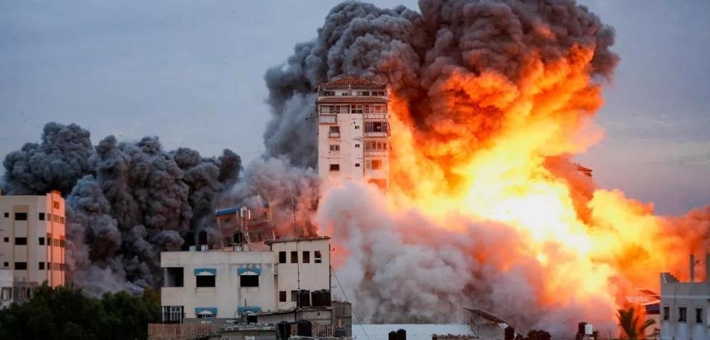 Fogo e fumaça saem de prédio bombardeado por Israel em Gaza (Foto: REUTERS/Ashraf Amra)