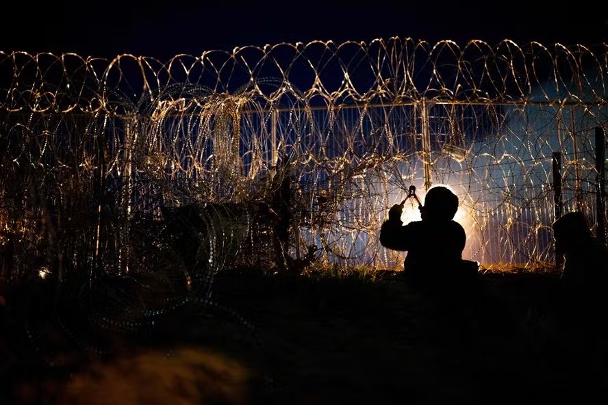 Imigrantes cortam cerca que divide a fronteira entre os EUA e México em El Paso, Texas — Foto: Brandon Bell/Getty Images/AFP