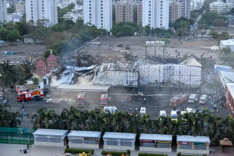 Foto aérea mostra bombeiros tentando extinguir um incêndio no parque de diversões em Rajkot. Pelo menos 16 pessoas morreram, a maioria crianças. — Foto: AFP
